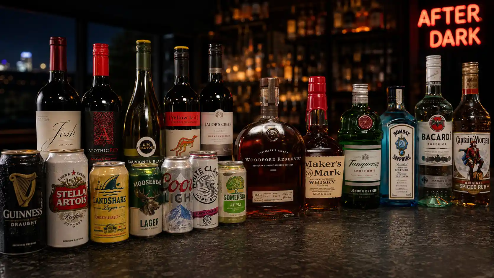 A full spread of cold craft beer cans, wine, bourbon, gin, and rum lined up on a bar counter — the kind of selection a corner-store cooler can't match